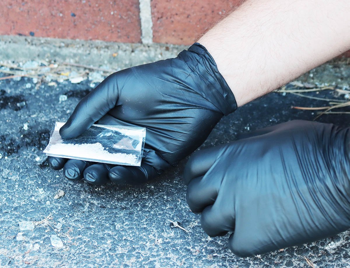 black gloves holding fentanyl on street